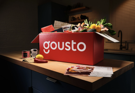 Gousto box full of fresh ingredients on the kitchen counter