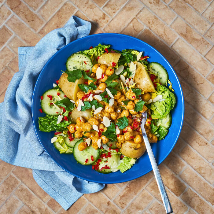 Creamy Coronation Chickpea Salad A blue pasta bowl with Gousto’s creamy coronation chickpea salad.